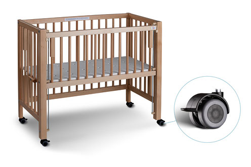 Wooden baby crib on wheels, with a close-up of one caster wheel.