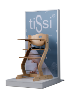 Wooden high chair displayed in front of a blue sign with white text.