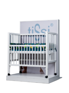 White crib with colorful bedding, surrounding a branded display background.