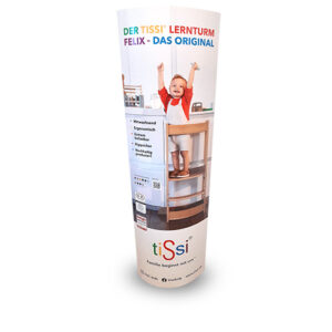 Child standing on wooden learning tower, smiling and raising arms in kitchen.